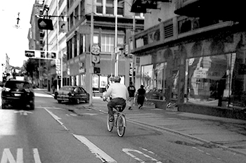 Man wearing helmet rides down 7th Street