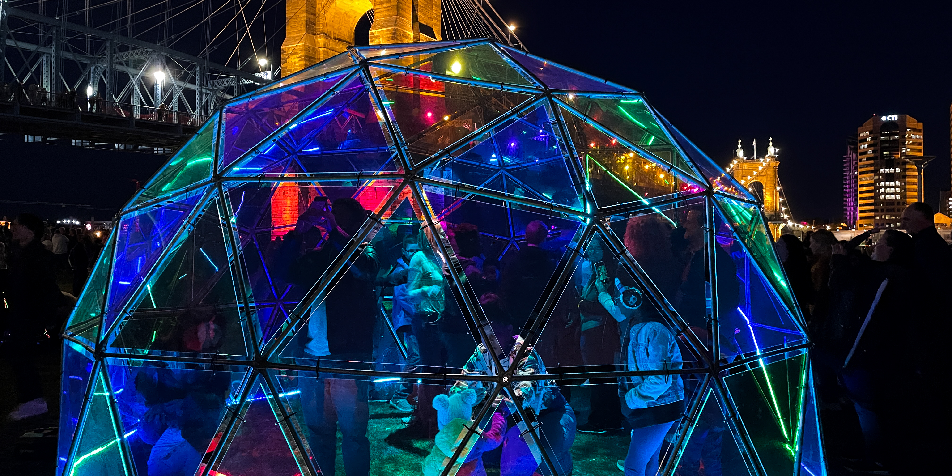 Colorful interactive igloo with Roebling Bridge in background