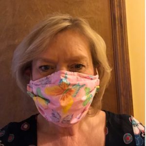 parks volunteer Sue wearing a pink with yellow flowers mask she made for staff