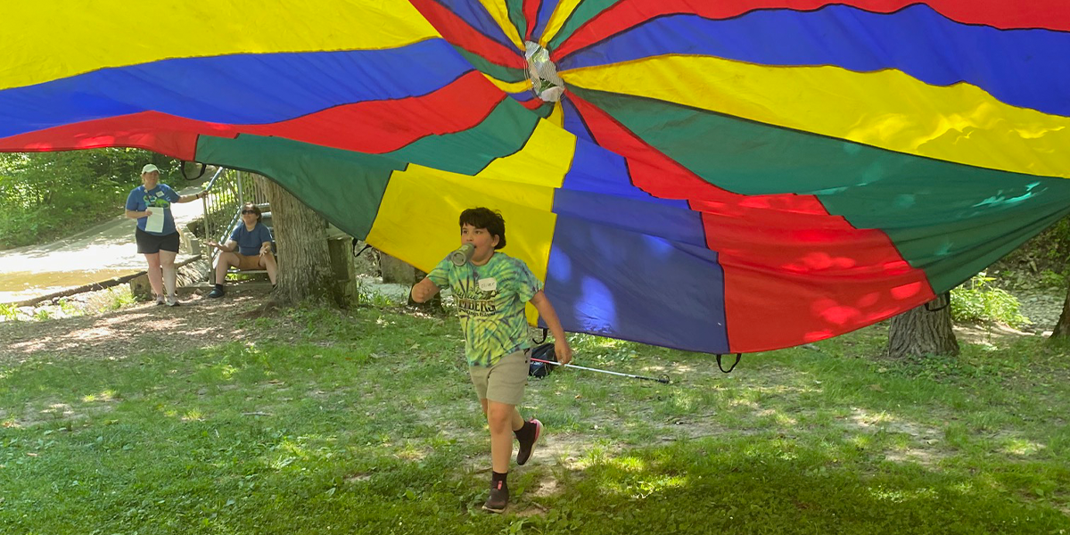 child under colorful tent